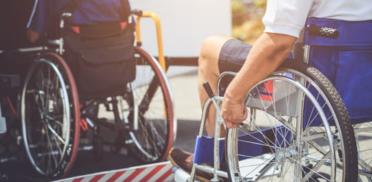 two people in wheelchairs boarding an accessible bus