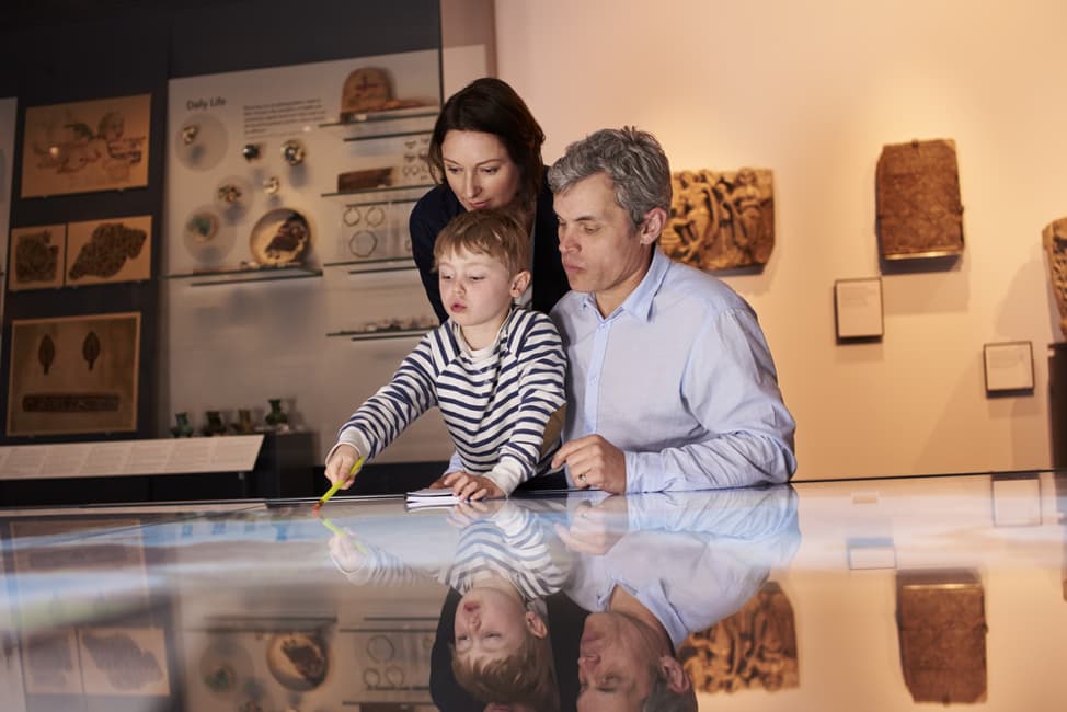 a family studies an exhibit at the Perot Museum